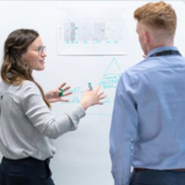 Student talking with teacher at a whiteboard 