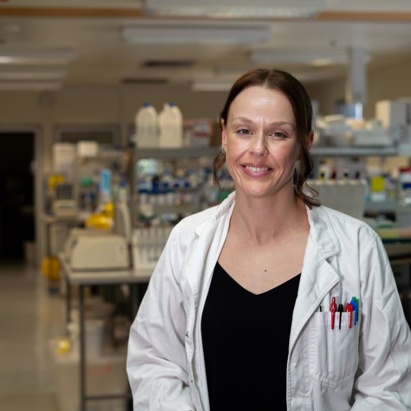 Dr Tessa Lord in a lab environment wearing a white lab coat, smiling to camera. From high-altitude hiking to sleep apnoea, study explores the impact on male fertility