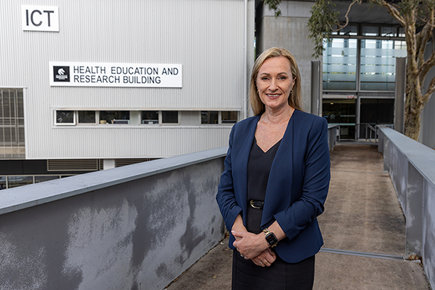 Professor Lisa Wood standing on bridge in front of building