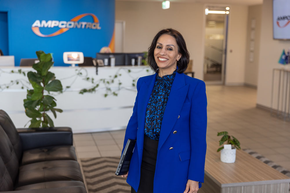 A woman standing in an office lobby smiling