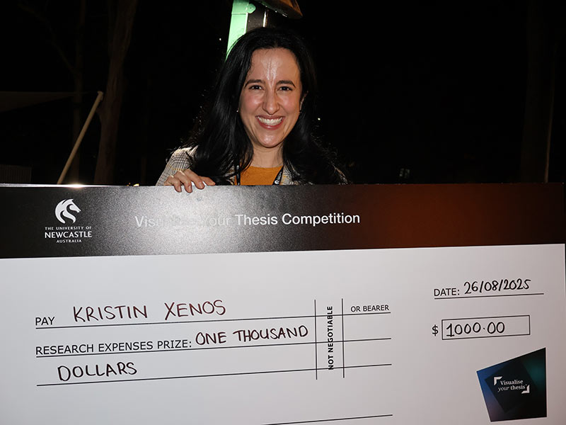 Woman smiling at the camera holding a novelty cheque