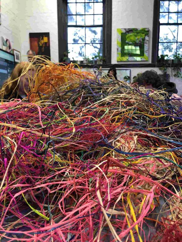 A table piled with different coloured fraffia used for weaving baskets
