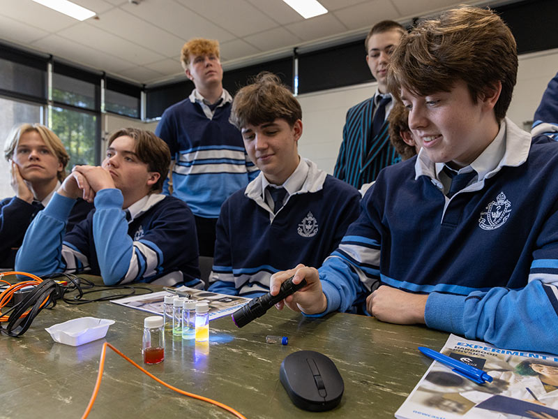 Student shining a light at tubes with liquid