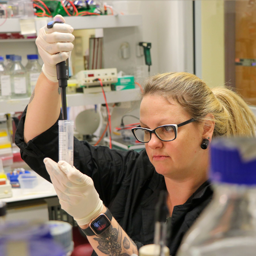 A woman using chemistry equipment.