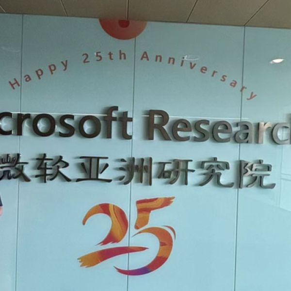 Dr Chen standing in front of a sign that says 