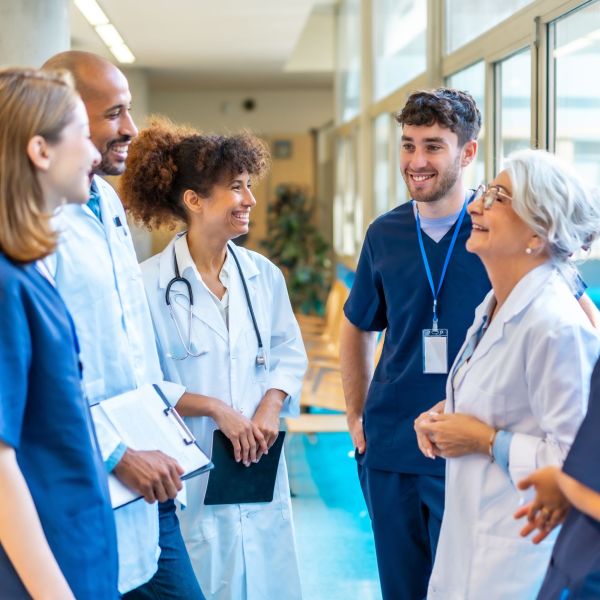 A group of staff in a hospital talking and smiling.