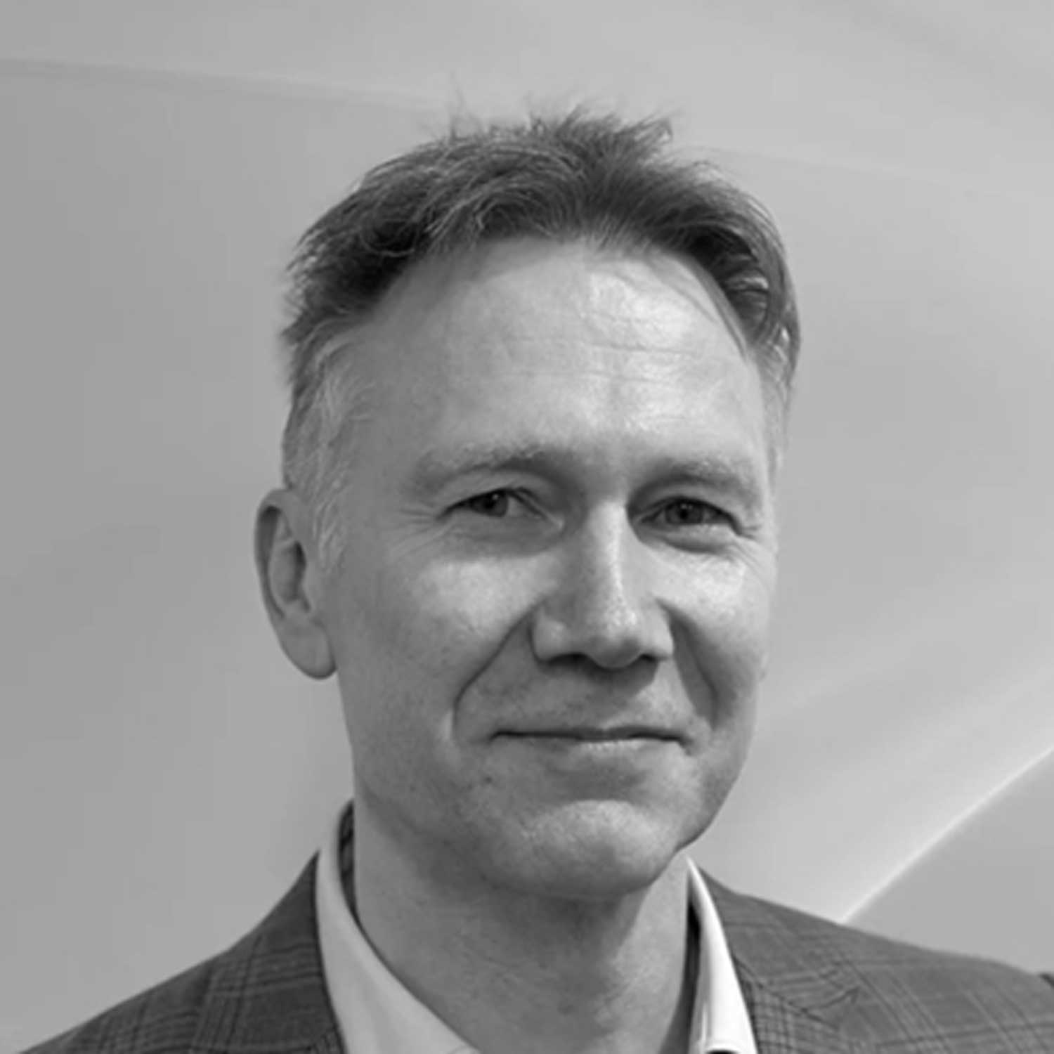 Black and white headshot of Gavin Rose, Director of The Phare Trust, smiling at the camera