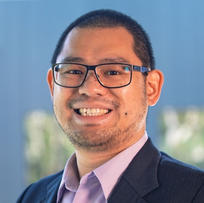  Headshot of man wearing glasses, business shirt and jacket smiling for the camera