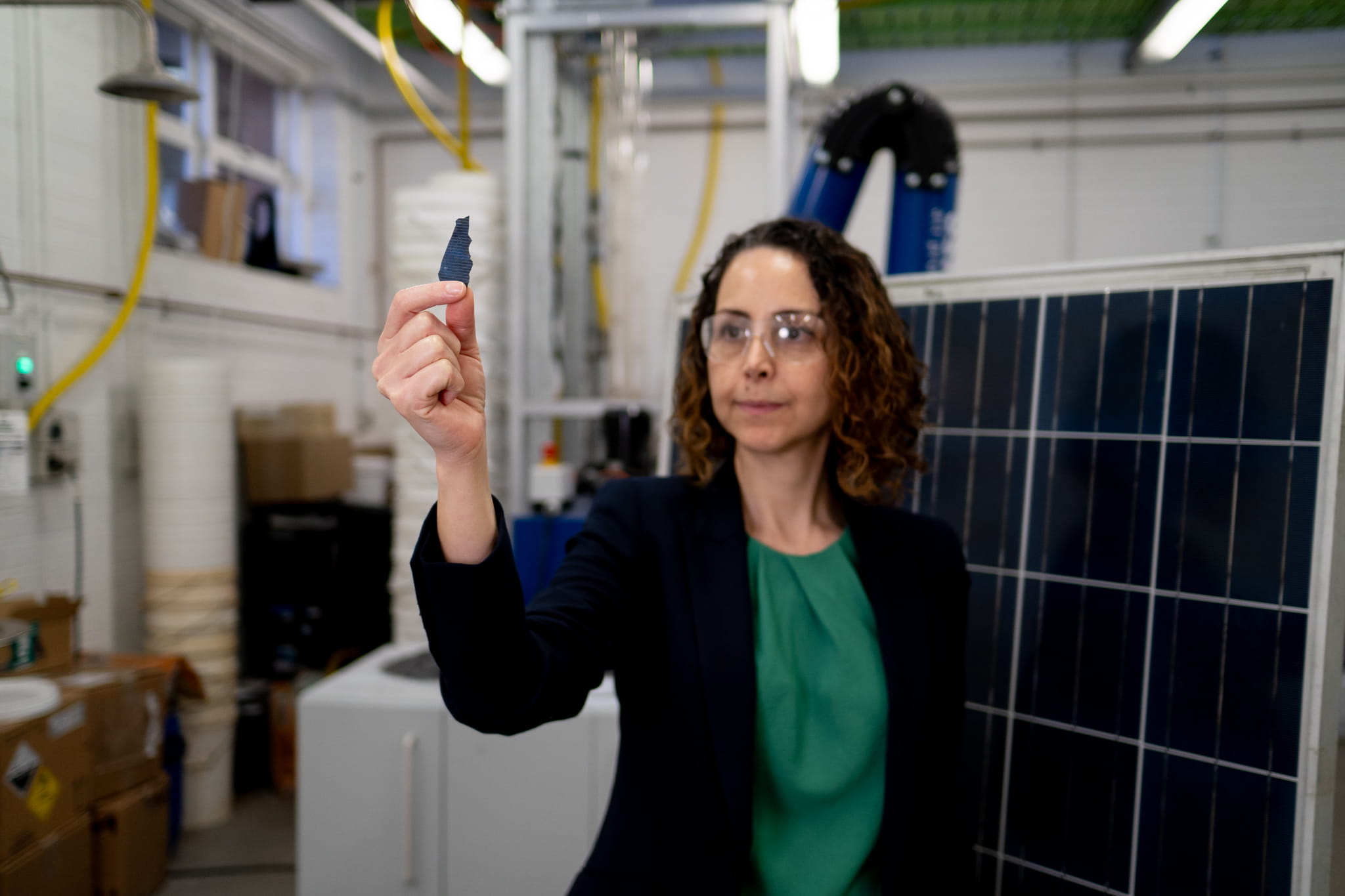 Associate Professor Mahshid Firouzi at the University of Newcastle holding solar cell material researcher holds up a small piece of solar cell material