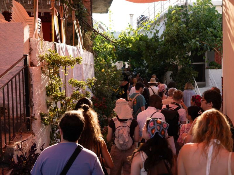  A diverse crowd of people walking closely together down a narrow alleyway.