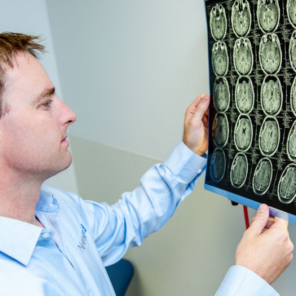 Dr Andrew Gardner examining brain scans. NRL pledges support to head injury research