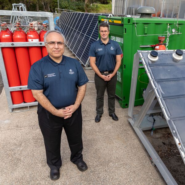 Professor Behdad Moghtaderi and Dr Andrew Maddocks with canisters of green hydrogen, PV array and their Hydro Harvester innovation