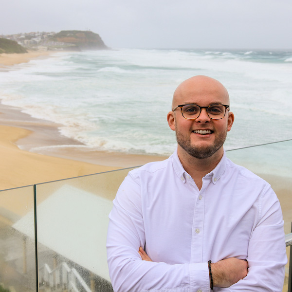 Image of Dr Andrew Magee with beach behind him