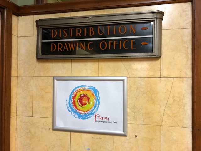 An old sign saying "Distribution/Drawing Office" with a new one that is a colourful spiral saying, "Purai"