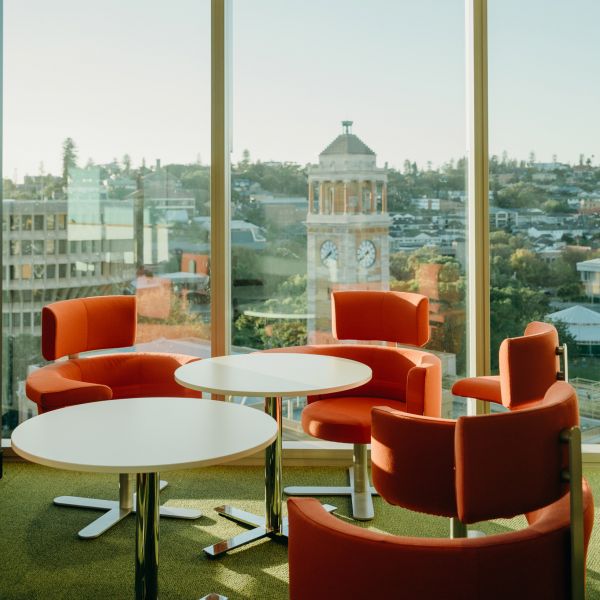 Image shows some chairs around a table looking out a window with a view of the clock tower
