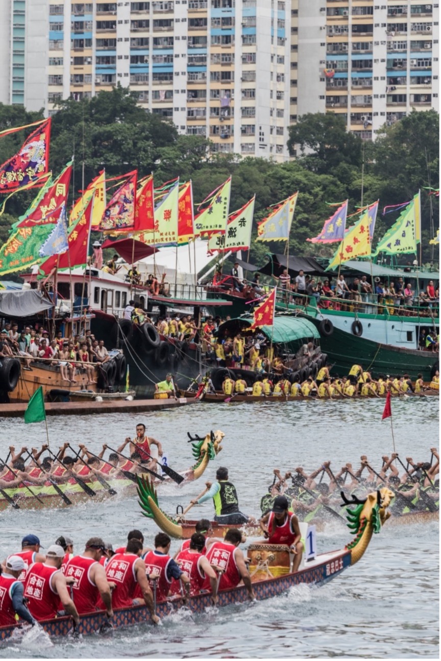 Photo of dragon boats racing with crowds watching