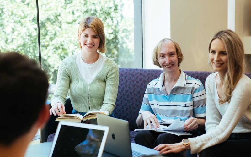People sit together happily in a meeting