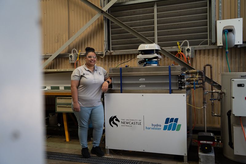 researcher stands next to a piece of equipment - the Hydro Harvester