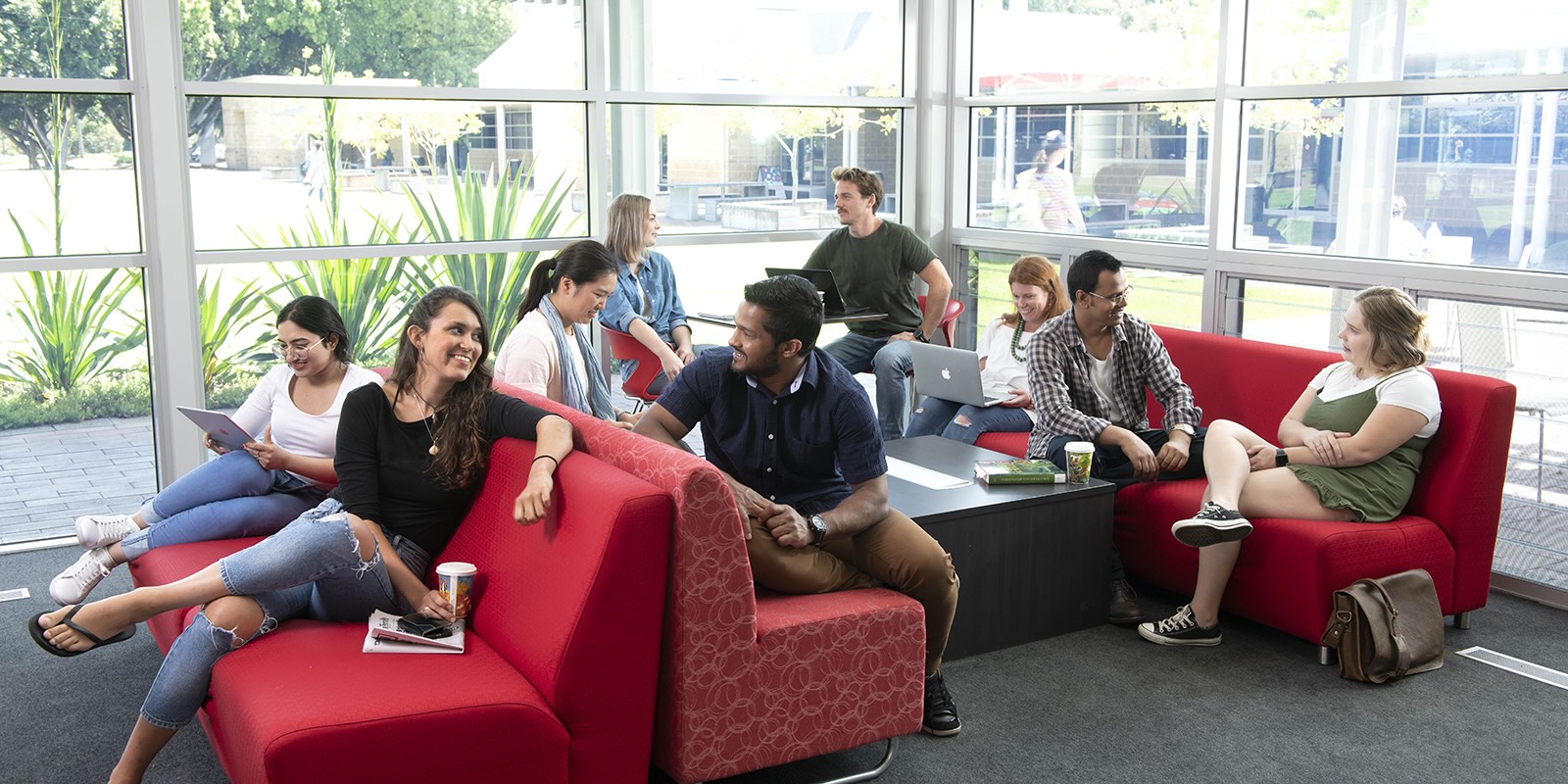 Ten university students sitting on lounges talking amongst themselves