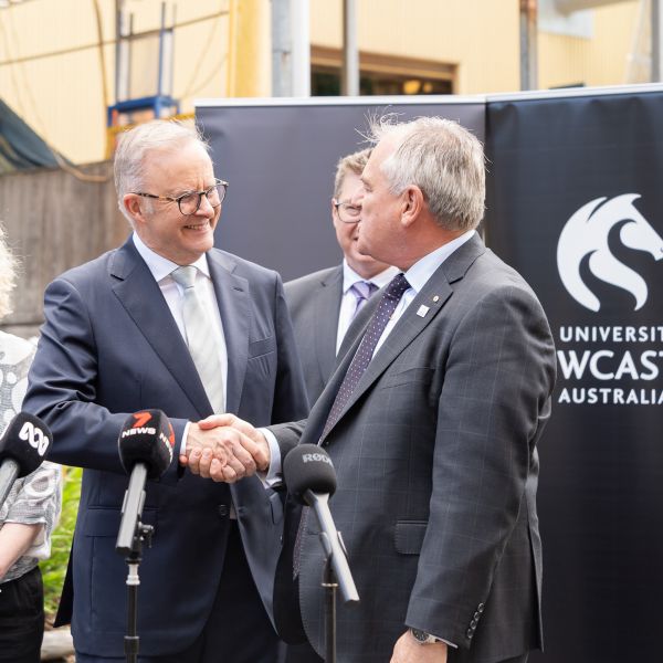 Prime Minister Anthony Albanese shaking hands with Vice Chancellor Alex Zelinsky in front of University logo. University secures $20.7m innovation facility - a fast track to net zero for industry.