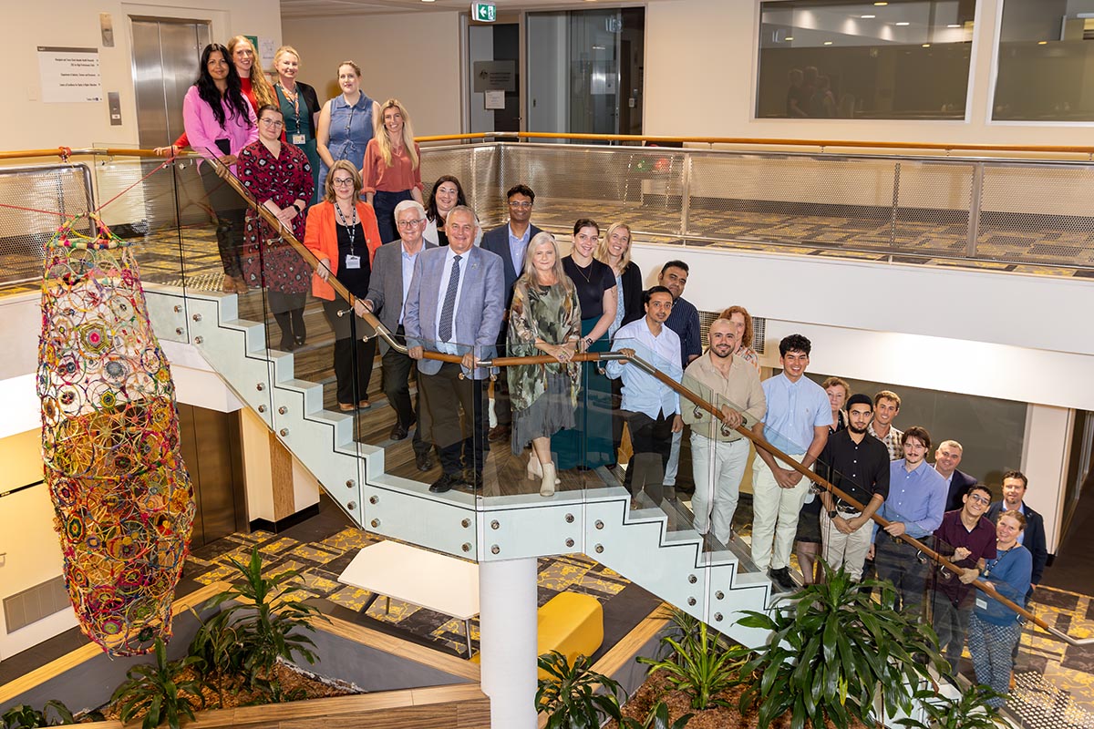 A group of people standing and posing on a staircase