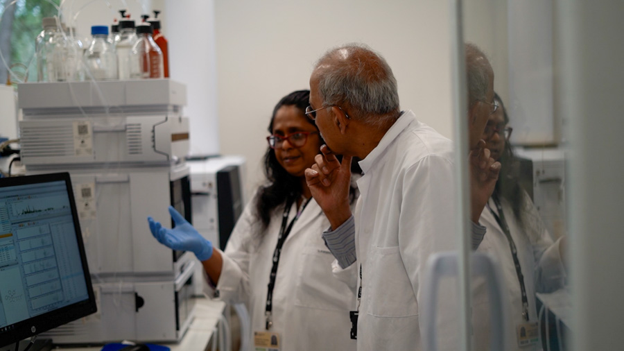 Ravi and Yoshida are pictured in a lab discussing results shown on a computer screen