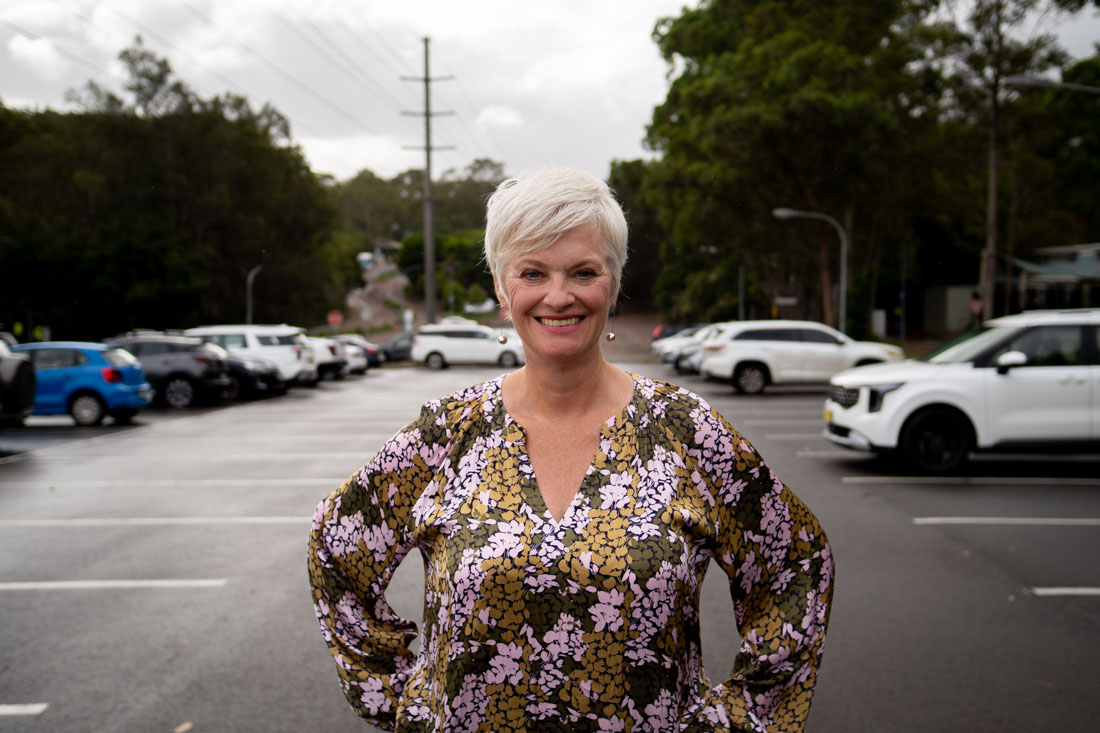 researcher smiling to camera with cars visible in the background