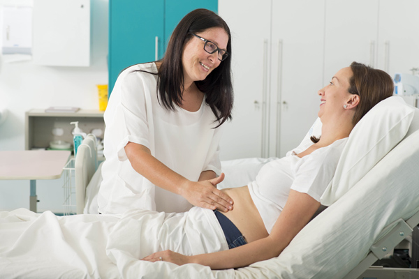 Midwife holding her hand on a pregnant woman's stomach