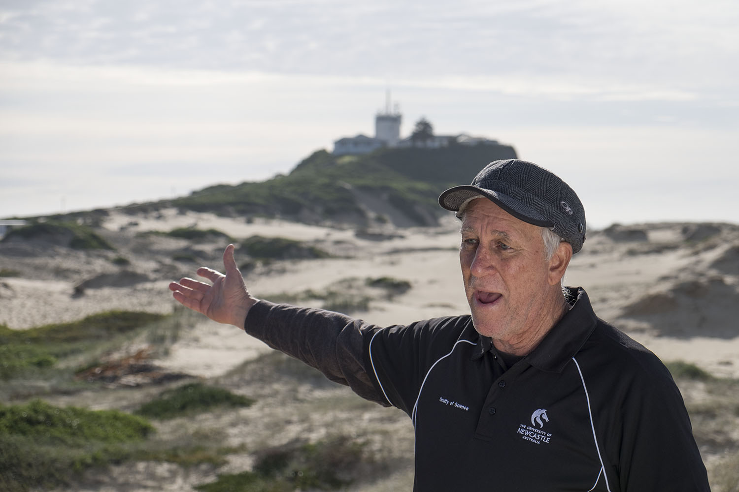 Professor Ron Boyd on Nobby's beach with Nobby's headland in the background