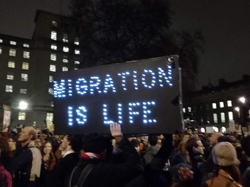 People protesting with sign that says 'Migration is life