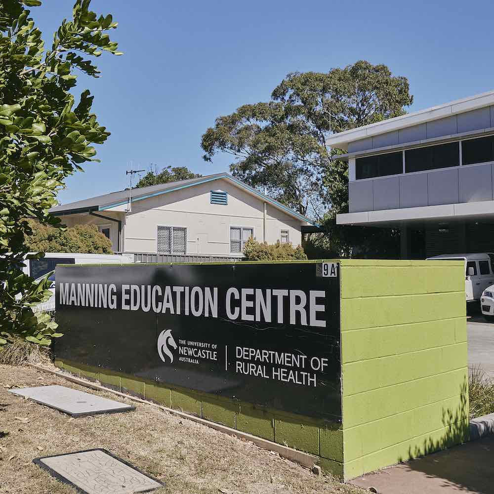 Manning Education Centre sign in front of grey and white building