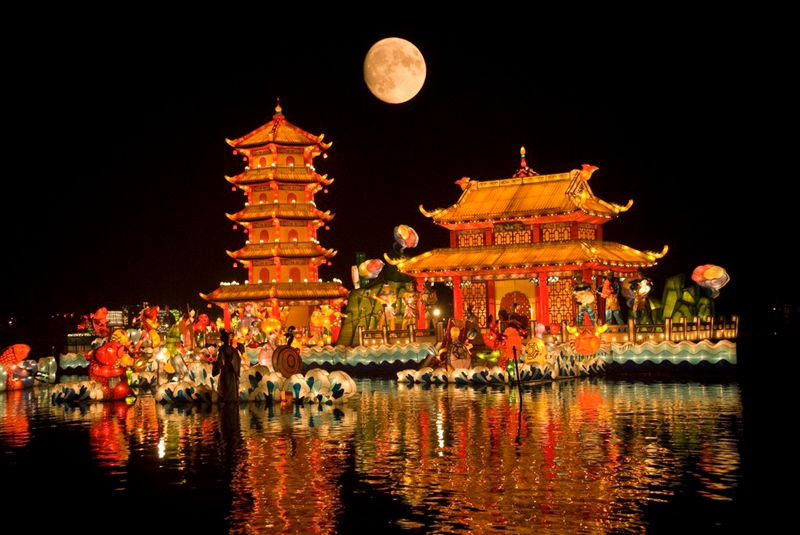 The moon behind a Chinese building at night