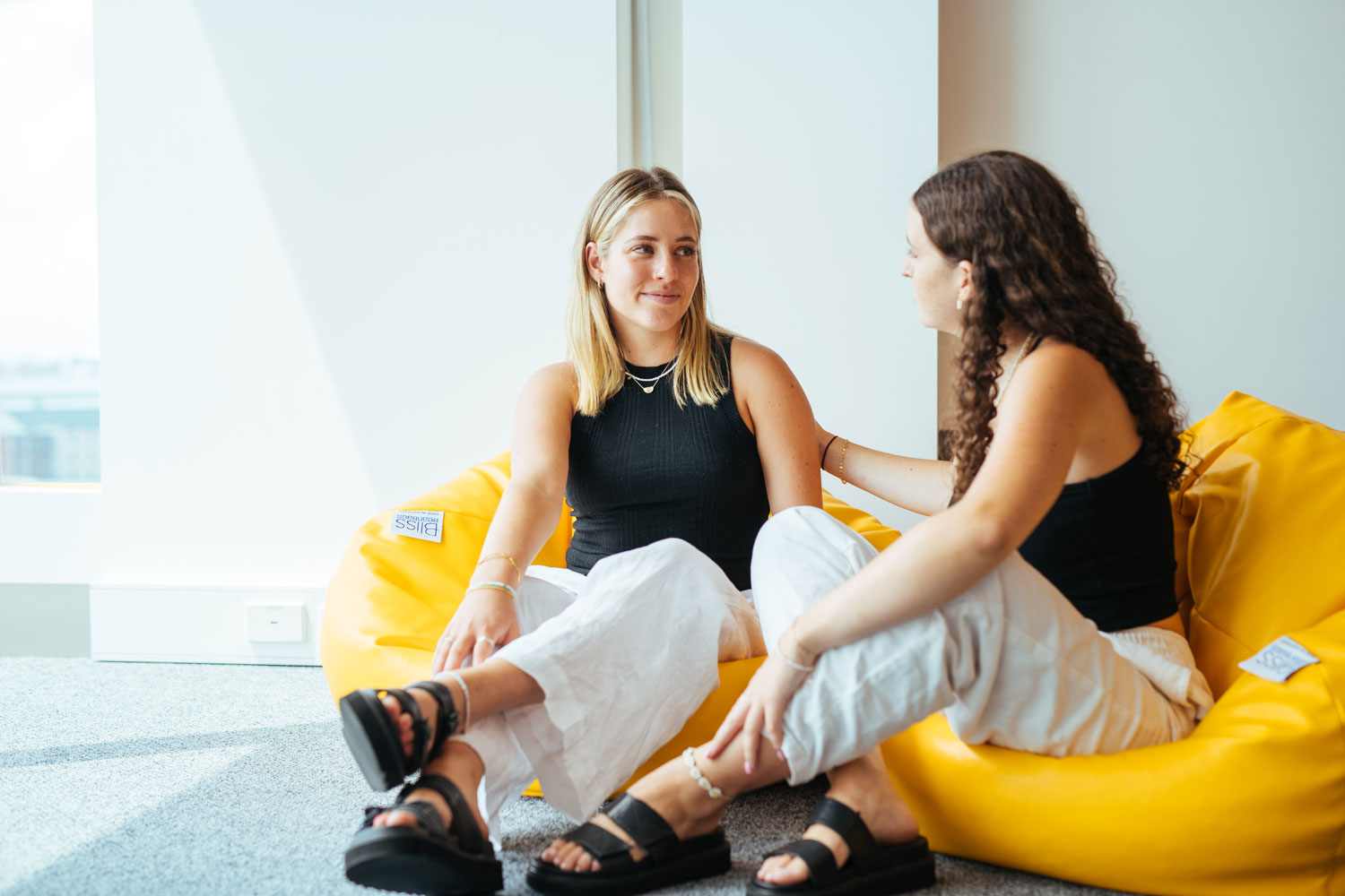 Two students sitting on beanbags having a deep ad meaningful conversation.  