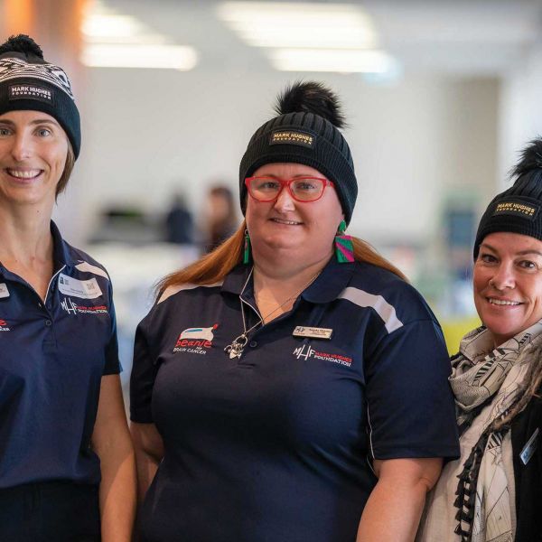 Three women in beanies smiling at the camera. Brain cancer team marks successful first year