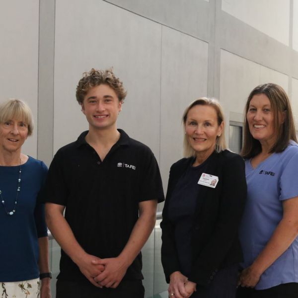 four people stand together smiling at the camera