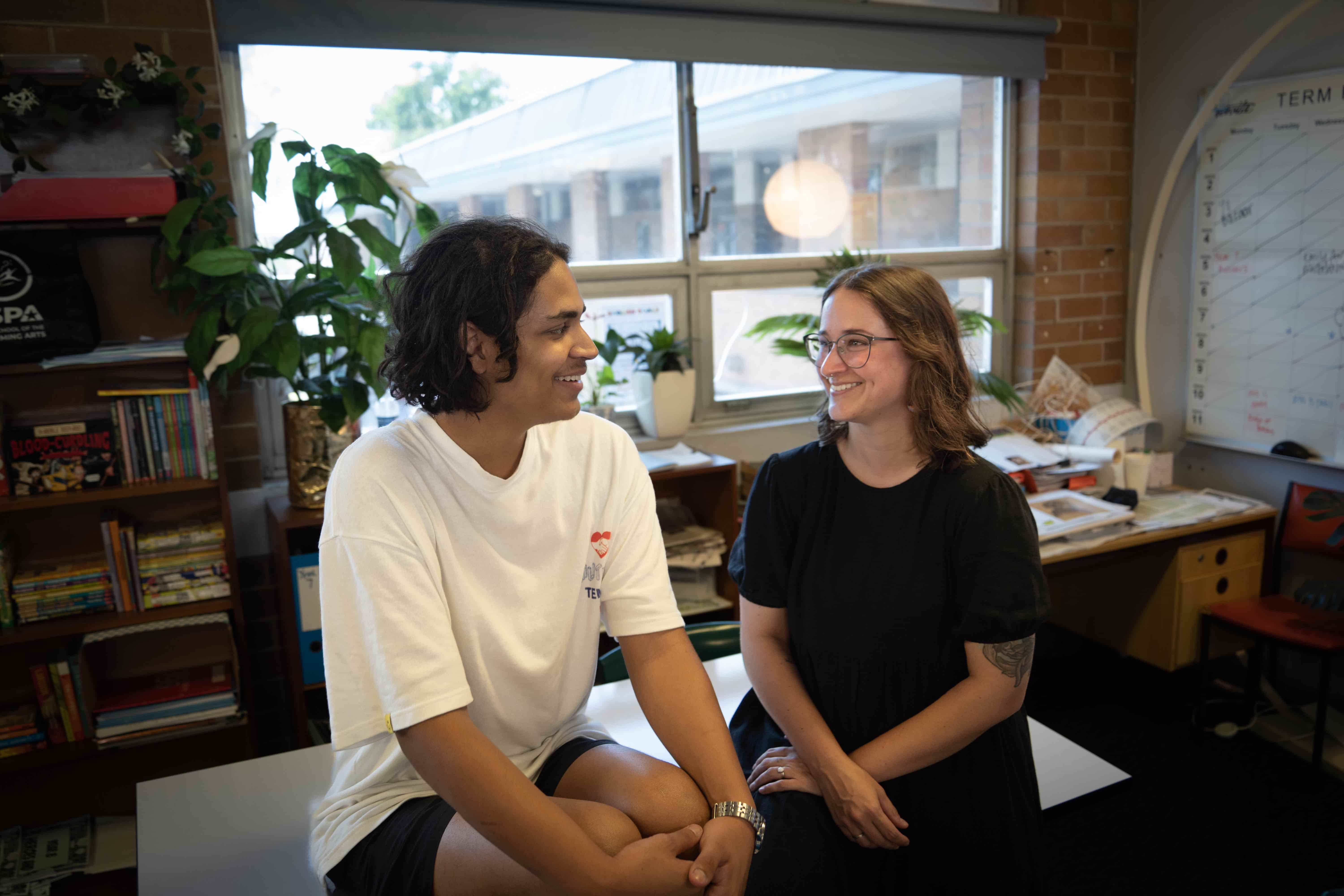 Kat and her student, Tom, chatting in a classroom