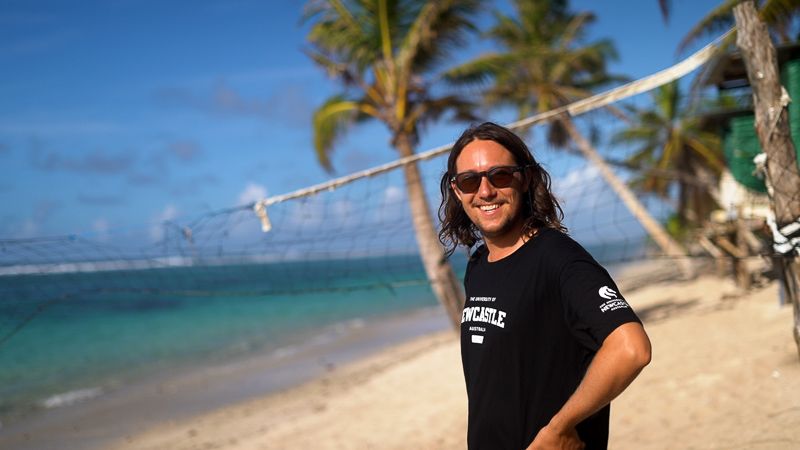 student smiling at the camera on a beautiful sunny beach in Samoa