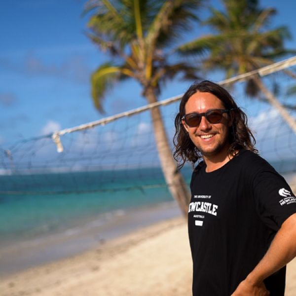 student smiling at the camera on a beautiful sunny beach in Samoa