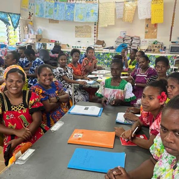 People in a classroom sitting around a desk