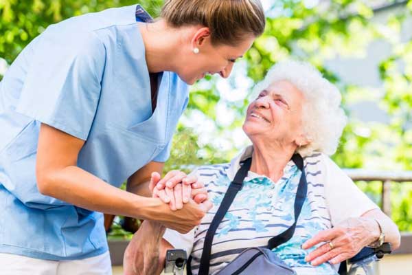 Pallative-care A nurse holding an elderly ladies hand