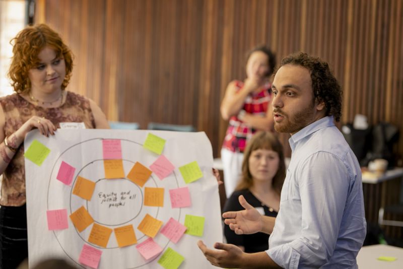 A man talking to a group of students in a seminar room