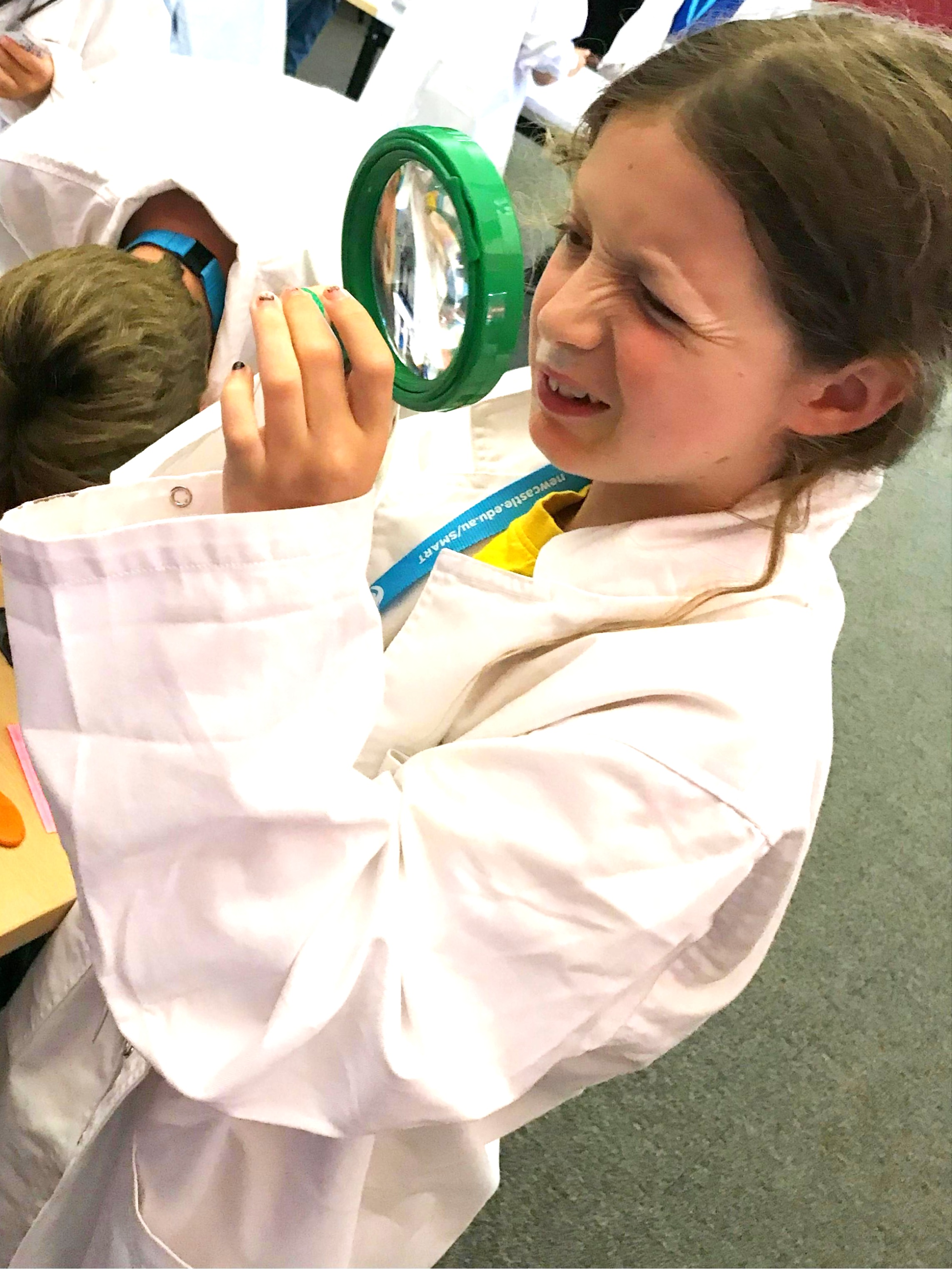 Girl looking through magnifying glass