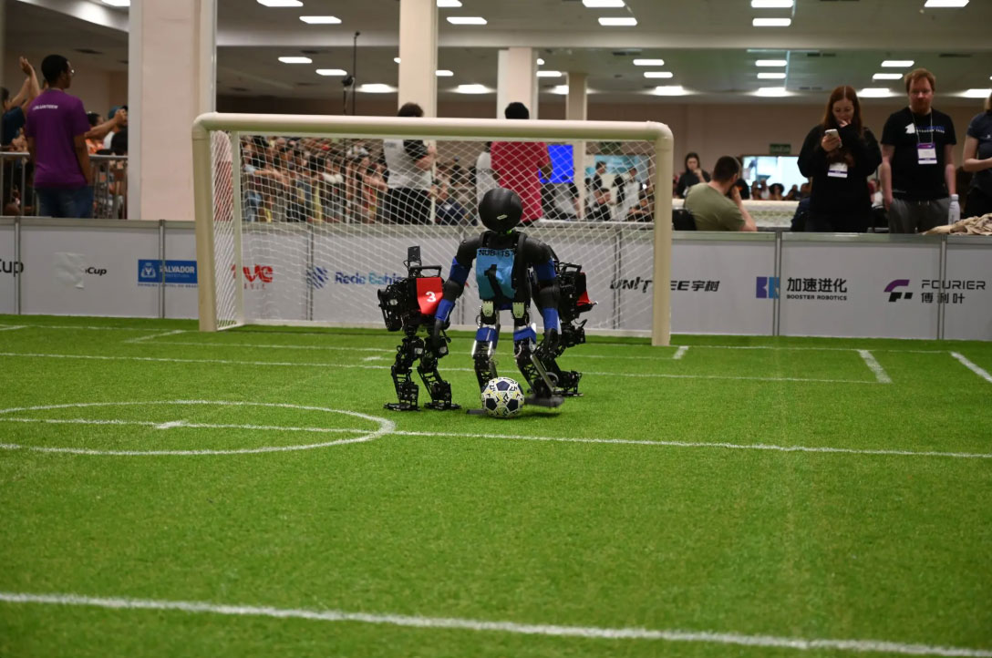 Small robots stand together on a fake field