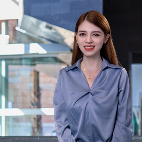 Alice smiling at camera in the Newcastle Business School NUSpace background