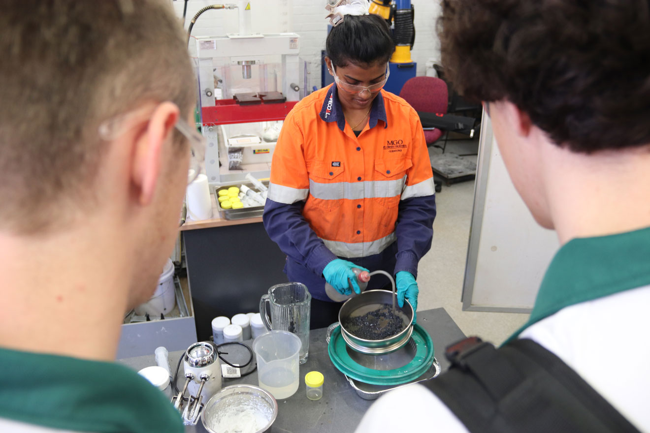 A staff member demonstrating a chemical reaction to students