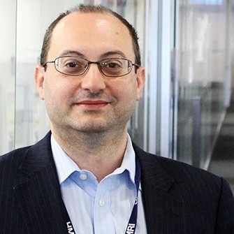 Headshot of man wearing glasses and business clothes