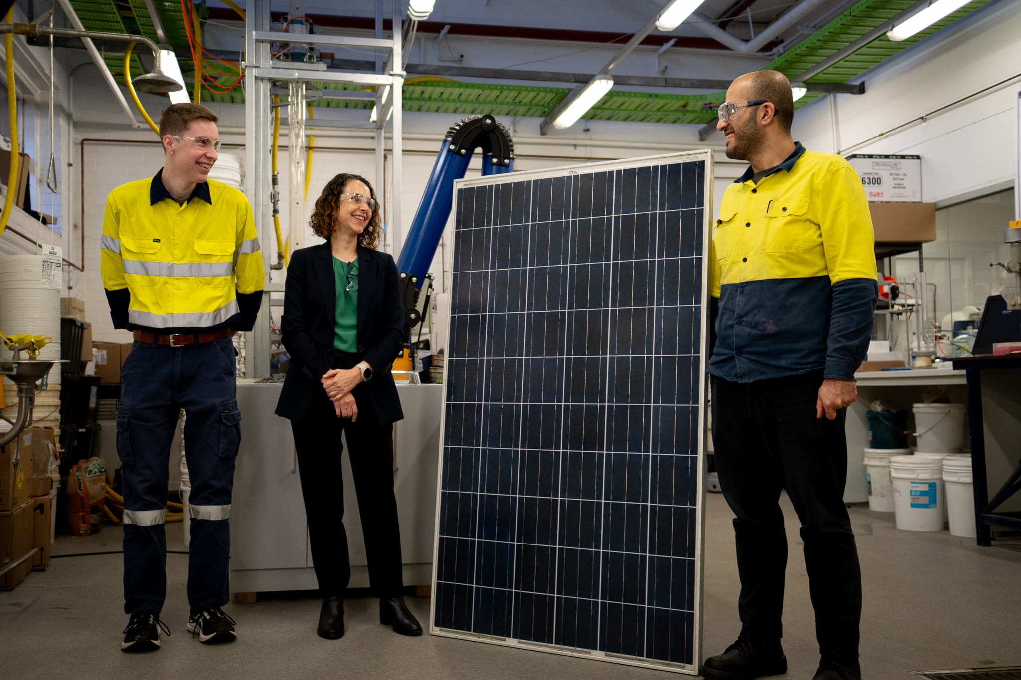 The University of Newcastle team pictured with an end-of-life solar panel a team of three researchers pictured with protective glasses on standing next to a solar panel