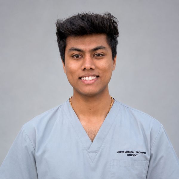 Proud student, Tarun Nagaraj, looking at the camera wearing his Joint Medical Program student doctor uniform. Scholarship supports rural healthcare