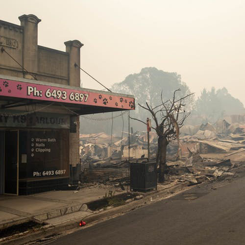 Image of burnt down buildings, smoke in the air, at Cobargo, NSW