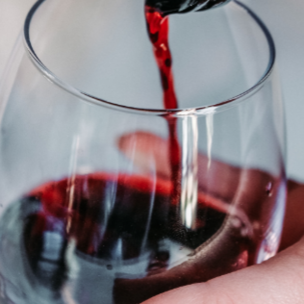 Woman pouring glass of wine. Women more likely to drink alcohol than men during coronavirus lock down